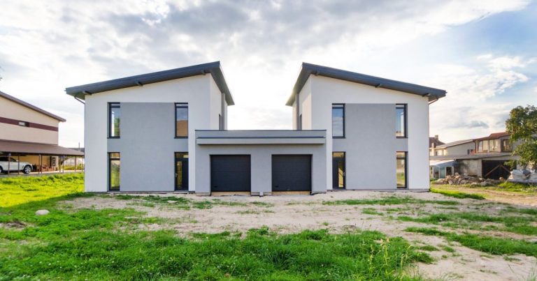Newly built white homes on a fresh green lawn