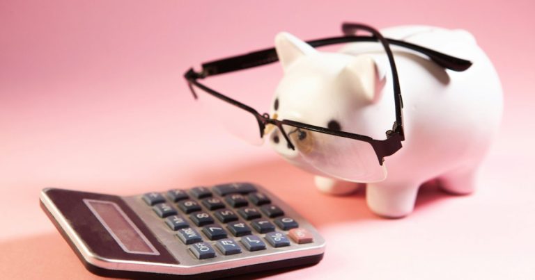 Piggy bank wearing glasses next to a calculator, figuring out seller concessions and closing costs