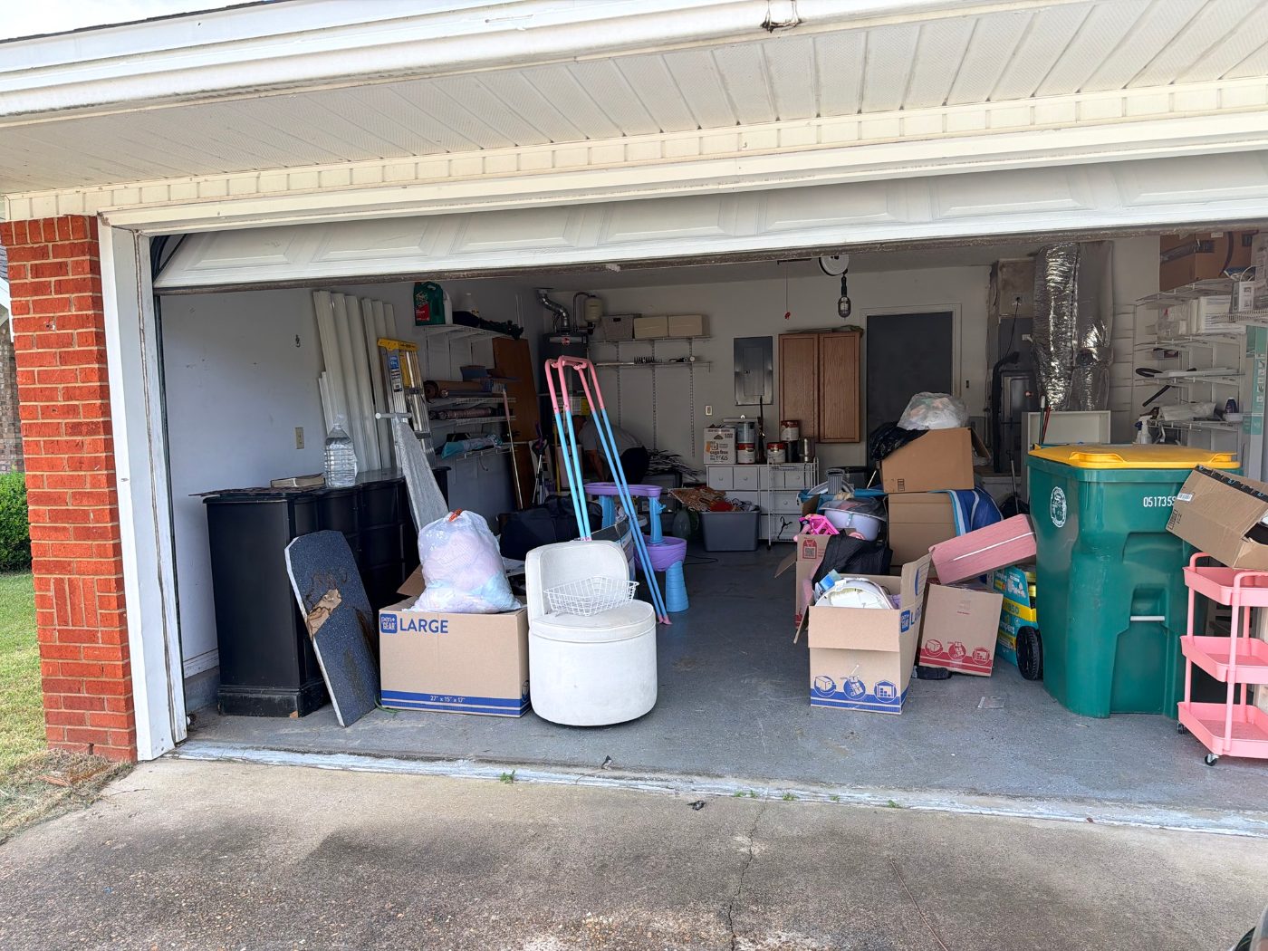 Open garage of a vacant listing being prepared for sale, with the gas water heater in the back